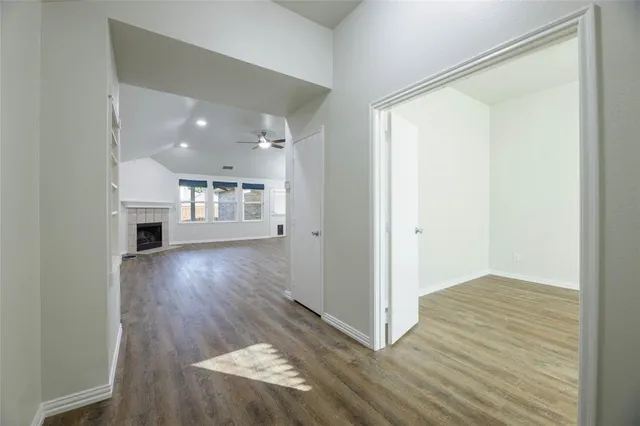 a view of a livingroom with wooden floor and a kitchen