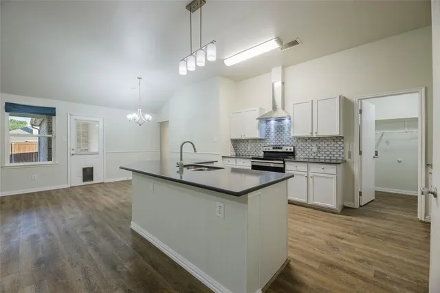 a kitchen with granite countertop a sink cabinets and wooden floor