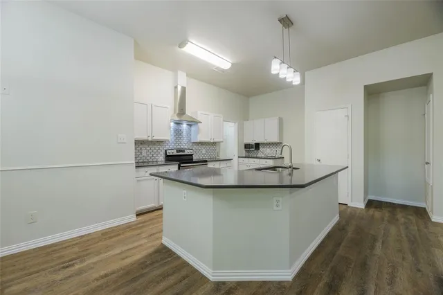 a kitchen with kitchen island a sink and wooden floor