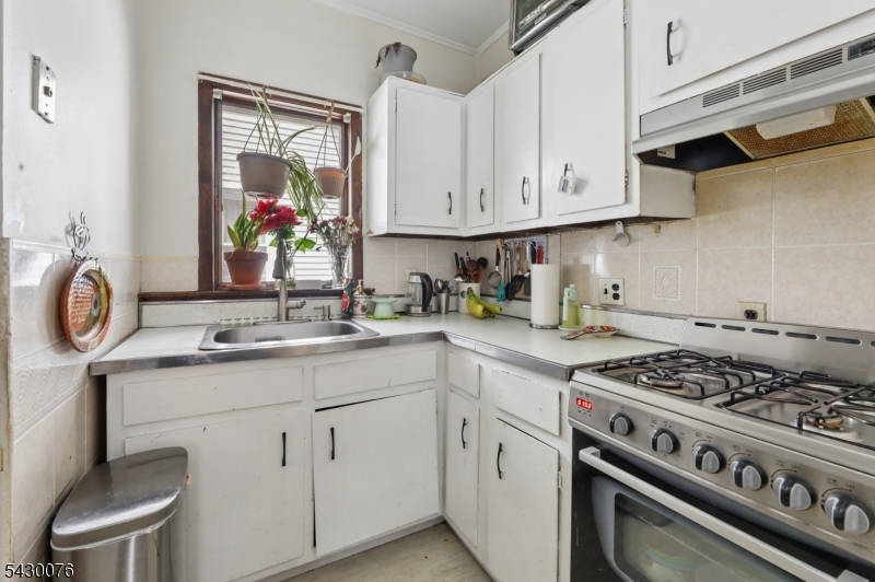 360 Rutherford Boulevard Clifton, NJ 07014 - Photo 10 of 42 a kitchen with white cabinets and appliances