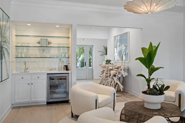 a living room with furniture a potted plant and a wooden floor
