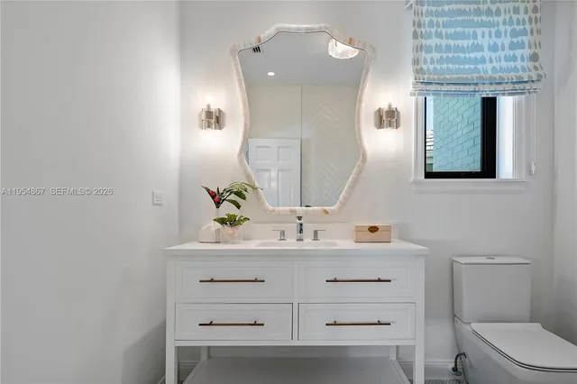 a bathroom with a sink a toilet and mirror