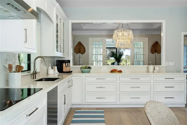 a kitchen with granite countertop a white cabinets and sink