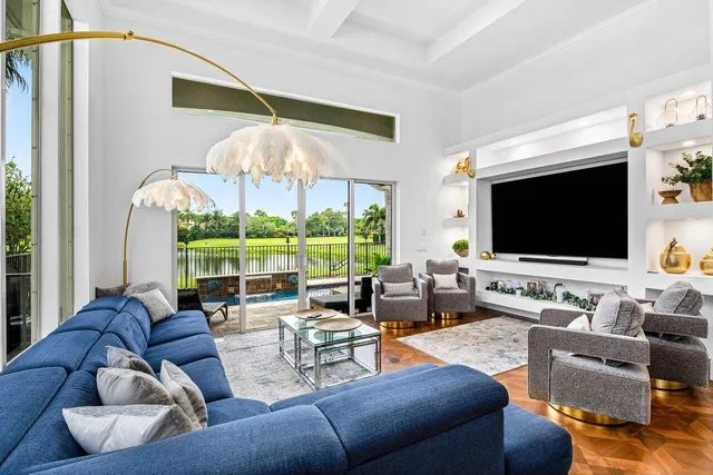 a living room with furniture a flat screen tv and a large window
