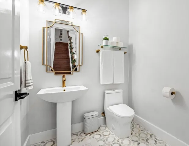 a bathroom with a toilet a sink and mirror