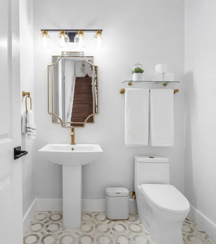 a bathroom with a toilet sink and mirror