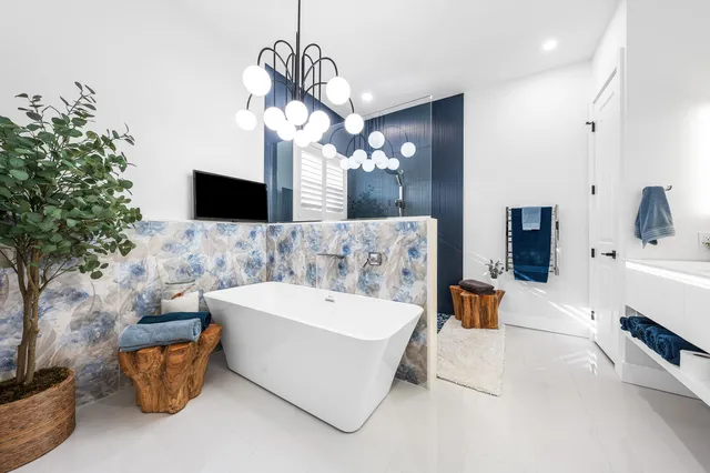 a spacious bathroom with a sink a mirror and chandelier