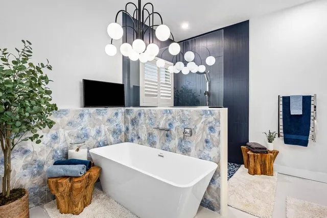 a bathroom with a sink a mirror and a potted plant