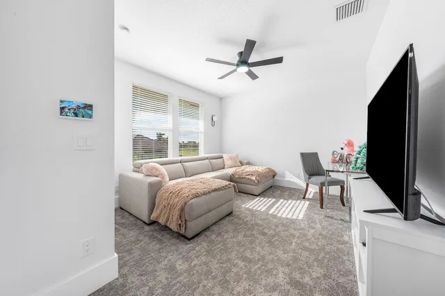 a bedroom with bed and a flat tv screen on dresser