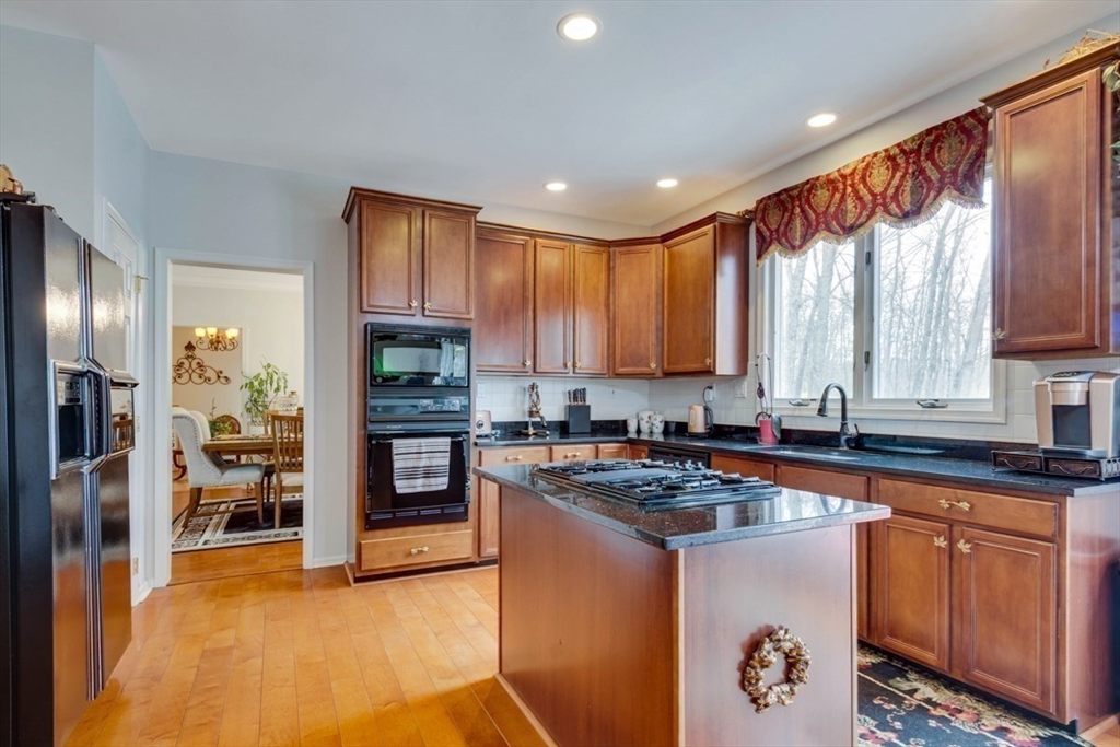 22 Robert Road Marlborough, MA 01752 - Photo 12 of 42 a kitchen with stainless steel appliances granite countertop a refrigerator a sink dishwasher a stove and white cabinets with wooden floor