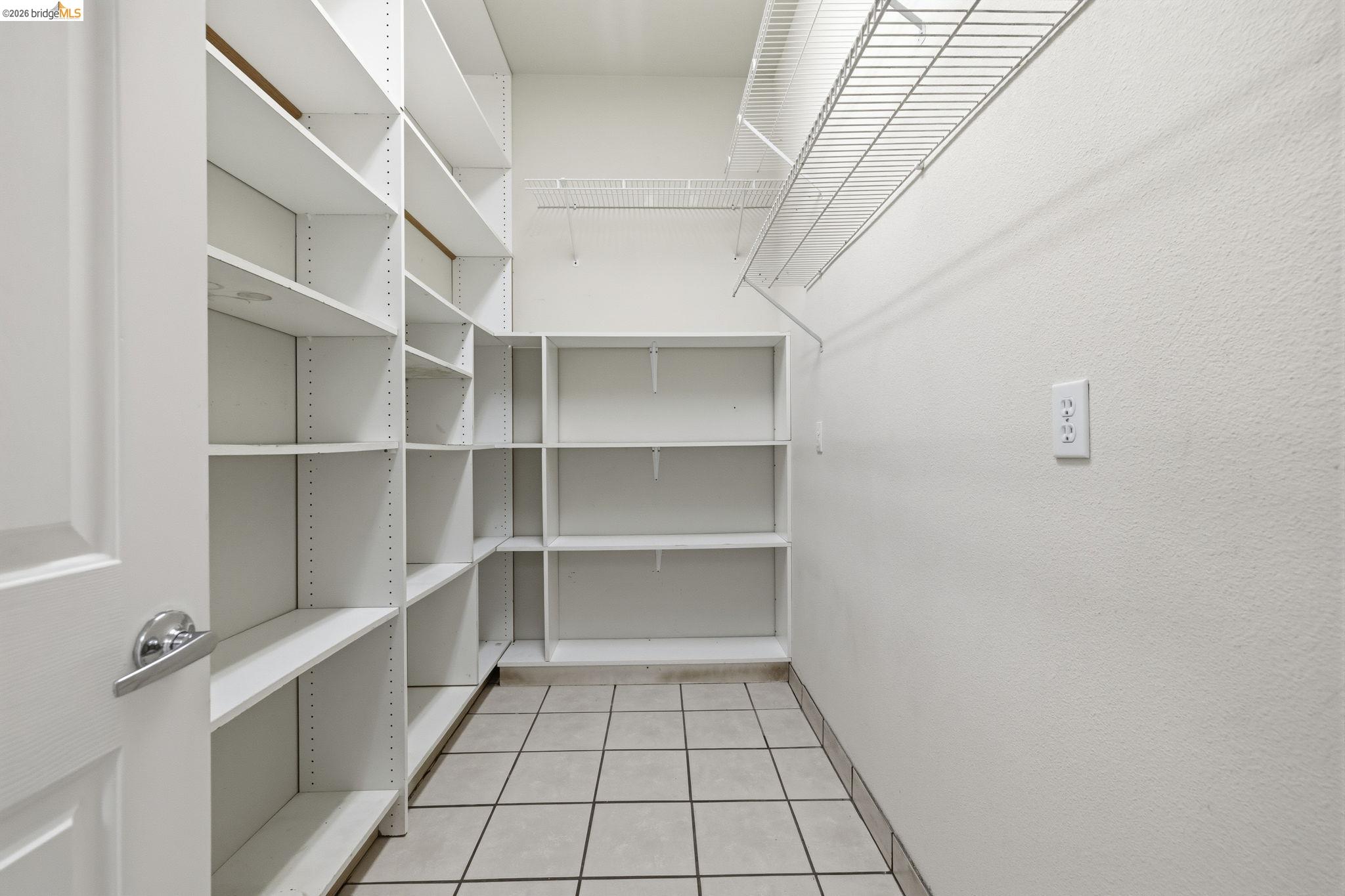 6242 Bluff View Road Copperopolis, CA 95228 - Photo 25 of 59 Walk-in pantry featuring extensive white shelving, wire shelving, and tile flooring