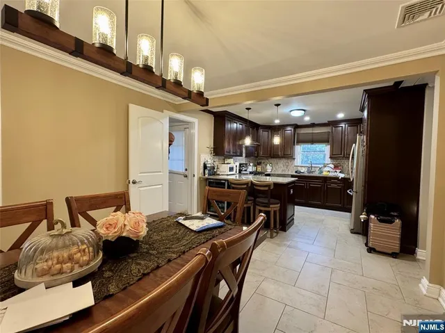 a kitchen with kitchen island a counter top space a sink stainless steel appliances and cabinets