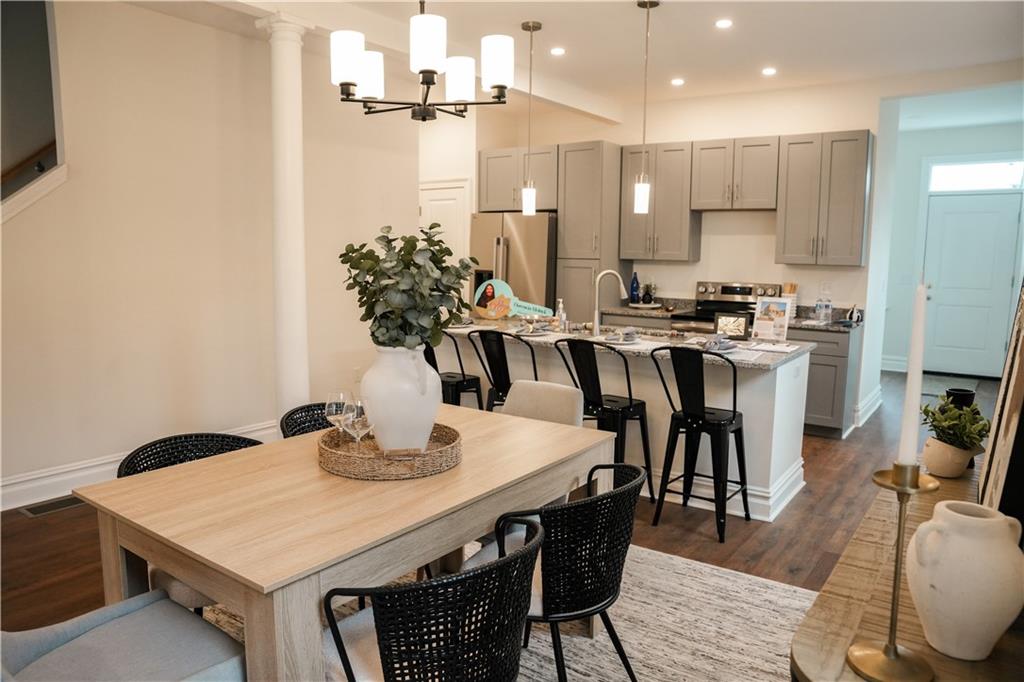 121 Shetland Street Pittsburgh, PA 15206 - Photo 13 of 37 a kitchen with stainless steel appliances kitchen island granite countertop a dining table chairs and white cabinets