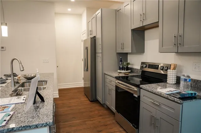 a kitchen with stainless steel appliances granite countertop a sink stove and refrigerator