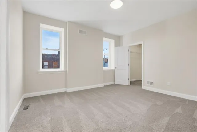 an empty room with windows and closet