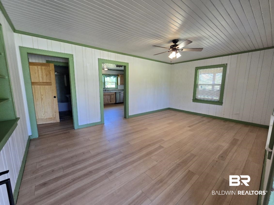 6464 Ridge Road Brewton, AL 36426 - Photo 6 of 14 Unfurnished living room featuring a ceiling fan, wooden walls, and light wood-style floors