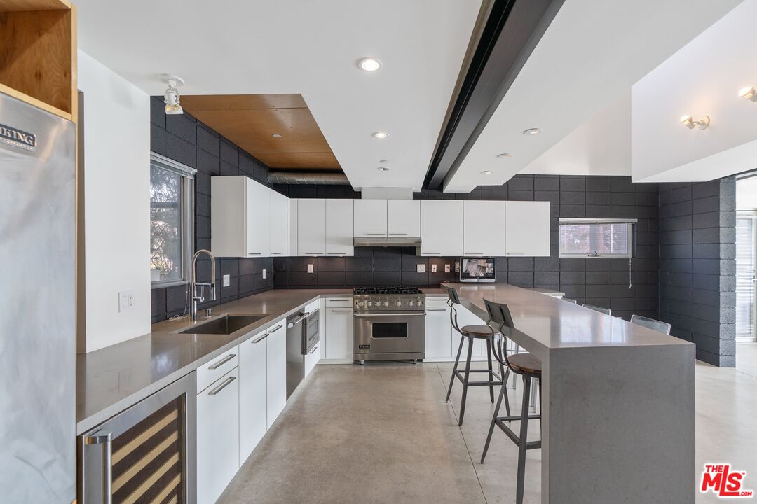 351 Sunset Avenue, Unit 1 Venice, CA 90291 - Photo 7 of 25 a kitchen with stainless steel appliances granite countertop wooden cabinets a sink dishwasher a stove and a refrigerator with wooden floor