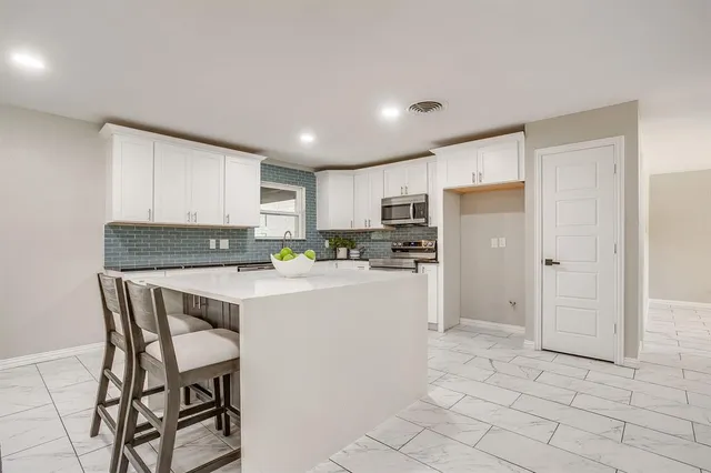 a kitchen with a refrigerator a counter top space and cabinets