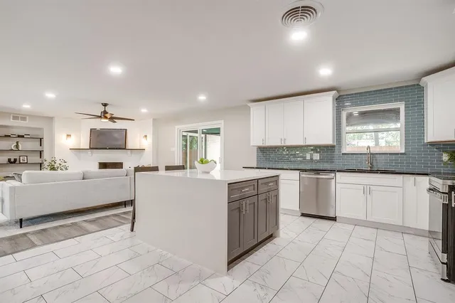 a large white kitchen with cabinets