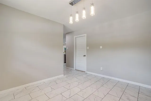 an empty room with chandelier fan