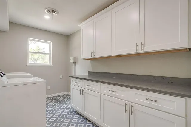 a kitchen with granite countertop white cabinets and a sink