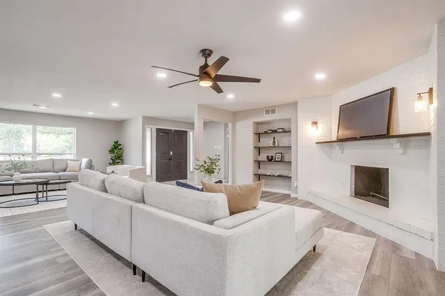 a living room with furniture a fireplace and a flat screen tv
