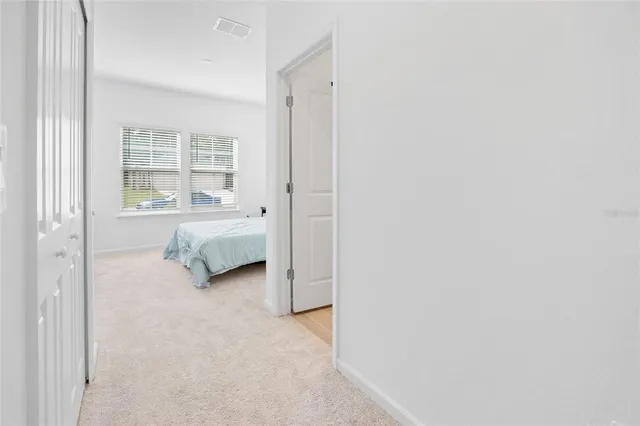 a view of a bedroom with a bed and a window