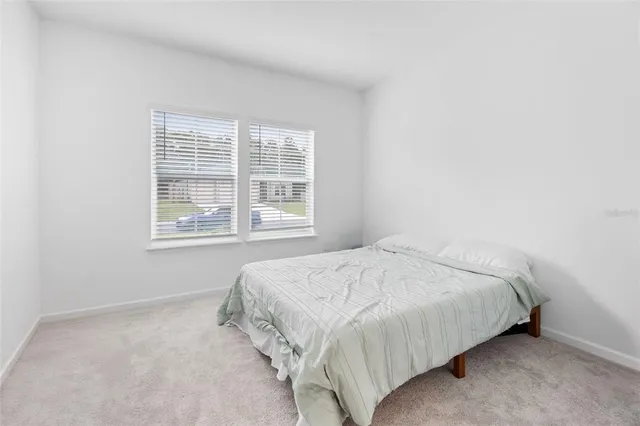 a bed sitting in a bedroom next to a window