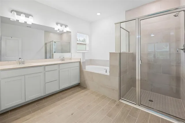 a spacious bathroom with a shower sink and mirror