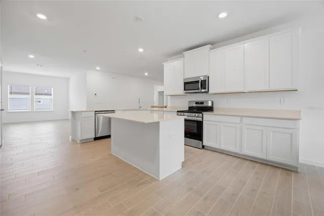 a kitchen with a white cabinets and wooden floor