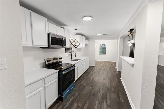 a kitchen with cabinets a microwave a stove and a refrigerator