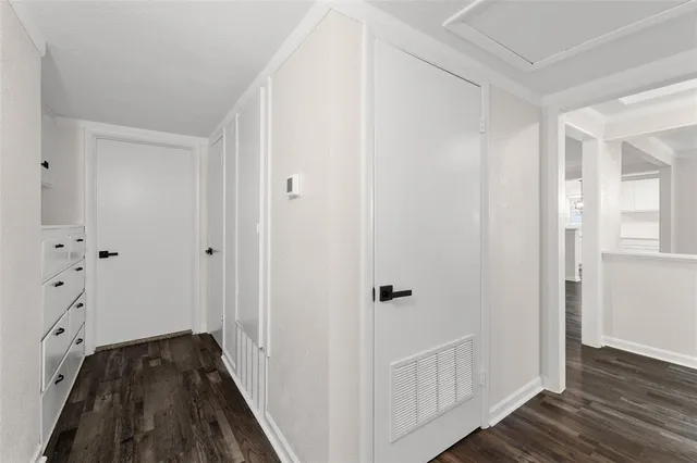 a view of a hallway with wooden floor and closet