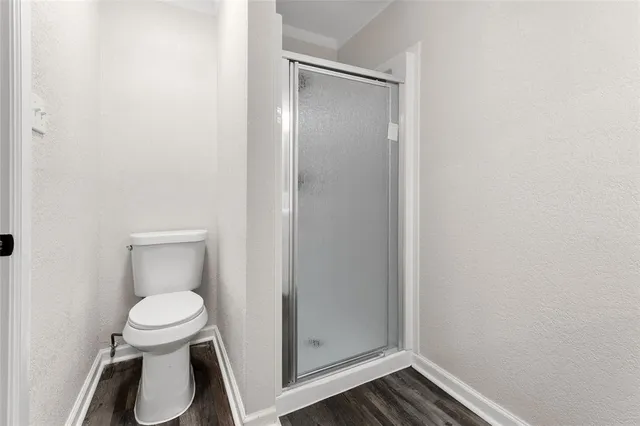 a white toilet sitting in a bathroom next to a sink
