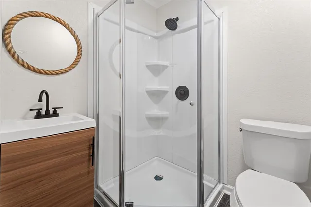 a bathroom with a sink a toilet and shower