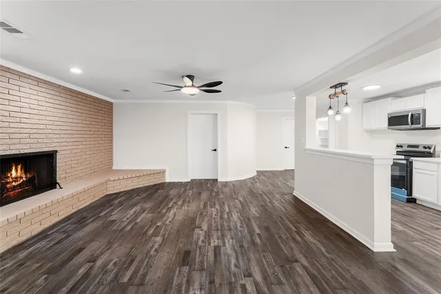 a view of a kitchen with wooden floor and a fireplace