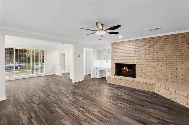 a view of empty room with wooden floor and fireplace
