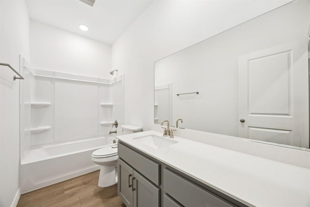1164 Daybreak Drive Allen, TX 75013 - Photo 24 of 28 a bathroom with a sink a toilet and a large mirror