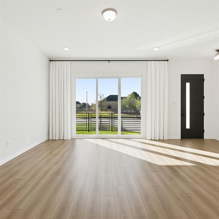 1164 Daybreak Drive Allen, TX 75013 - Photo 7 of 28 a view of an empty room with wooden floor and a window