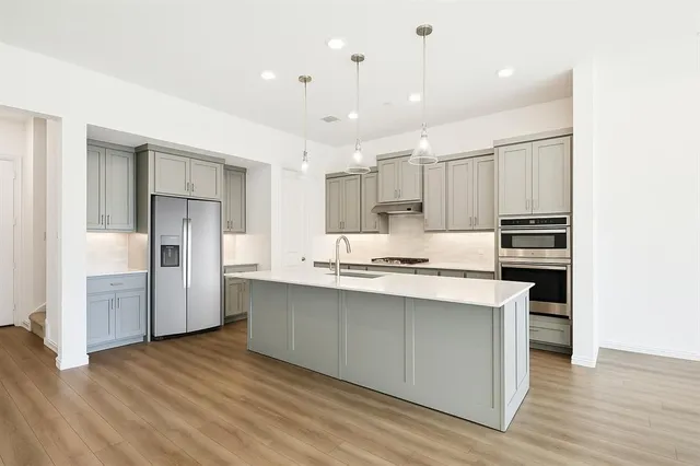 a kitchen with kitchen island white cabinets and stainless steel appliances