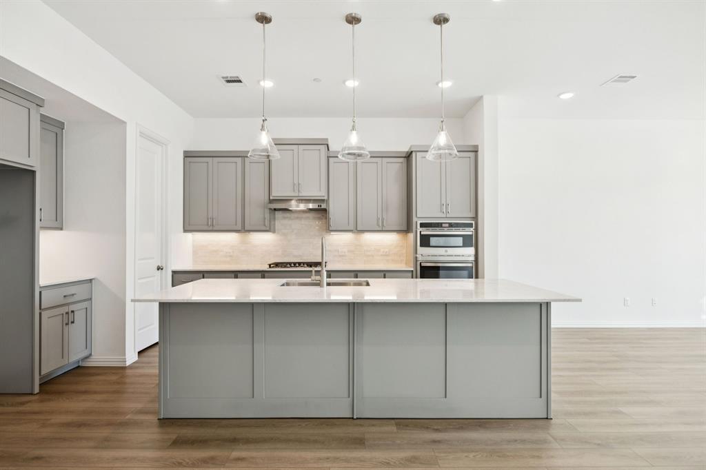 1164 Daybreak Drive Allen, TX 75013 - Photo 10 of 28 a kitchen with kitchen island white cabinets and stainless steel appliances