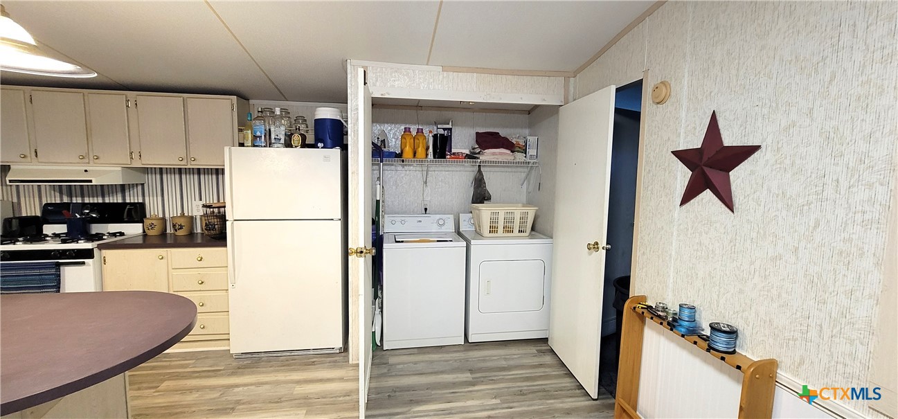 406 Denver Avenue Seadrift, TX 77983 - Photo 13 of 24 a kitchen with a refrigerator a stove top oven a washer and dryer