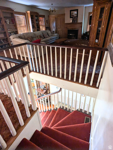 190 North 200 E Street Beaver, UT 84713 - Photo 29 of 40 Staircase with red carpeted treads and white balusters, featuring dark wood handrails