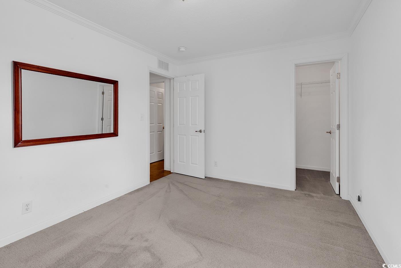 301 Walden Lake Road Conway, SC 29526 - Photo 12 of 37 Unfurnished bedroom featuring carpet, ornamental molding, and a walk in closet