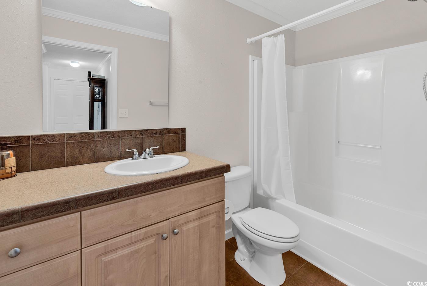 301 Walden Lake Road Conway, SC 29526 - Photo 13 of 37 Bathroom featuring crown molding, vanity, shower / tub combo, decorative backsplash, and tile patterned floors