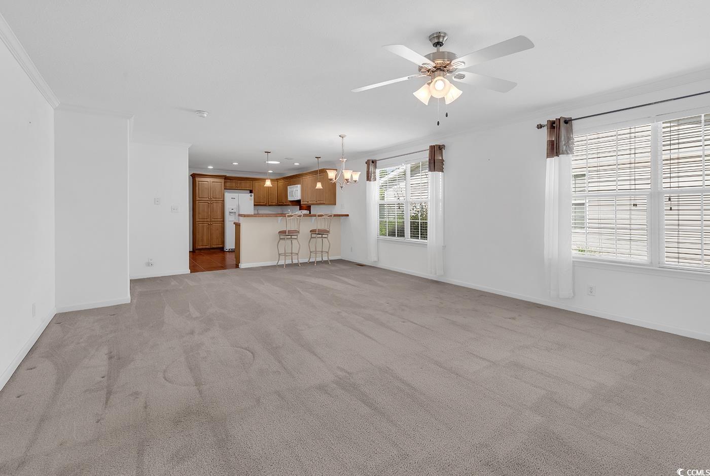 301 Walden Lake Road Conway, SC 29526 - Photo 9 of 37 Unfurnished living room with light carpet, a chandelier, a ceiling fan, crown molding, and recessed lighting