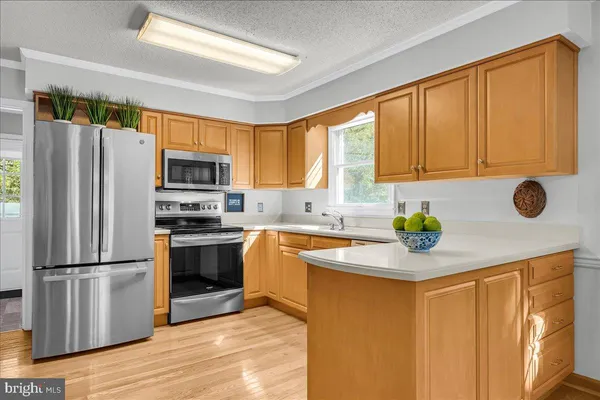 a kitchen with stainless steel appliances granite countertop a refrigerator sink stove microwave and cabinets