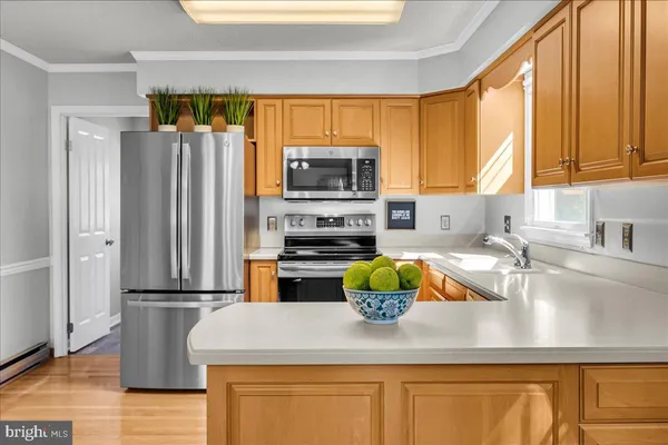 a kitchen with stainless steel appliances granite countertop a refrigerator a stove a sink and a microwave