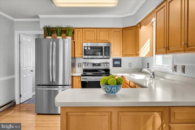 a kitchen with stainless steel appliances granite countertop a refrigerator a stove a sink and a microwave