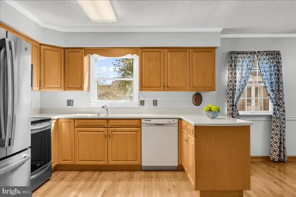 a kitchen with stainless steel appliances a sink cabinets and wooden floor