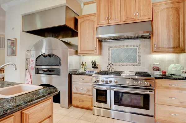 a kitchen with granite countertop a stove sink and cabinets